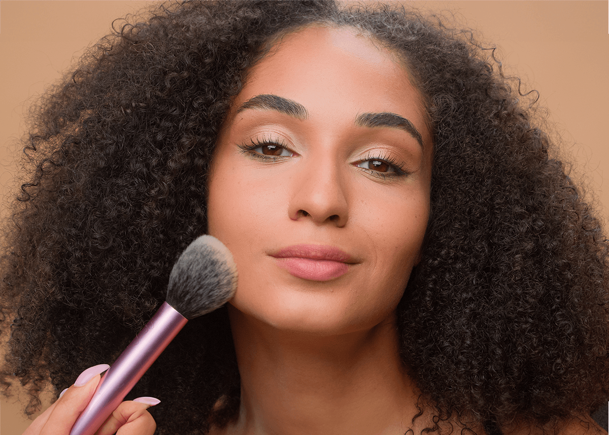 Girl applying bronzer to face