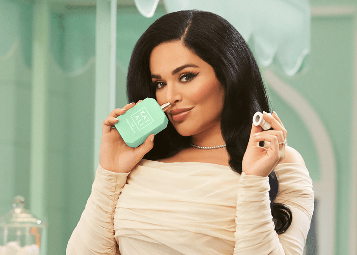 huda beauty posing with kayali pistachio