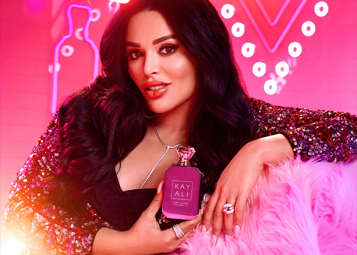 huda beauty posing with kayali sweet diamond fragrance