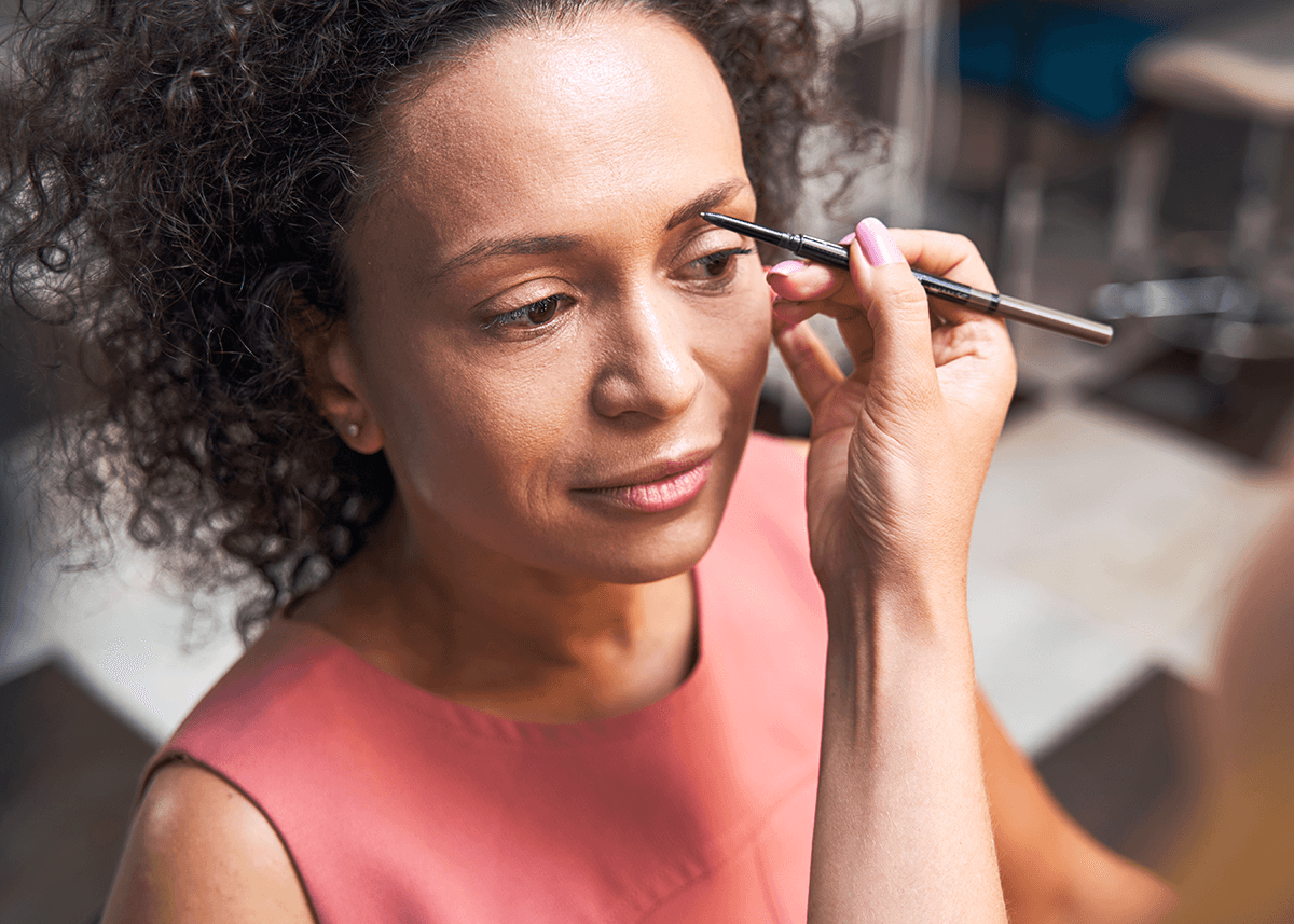 mature woman getting eyebrows done in salon