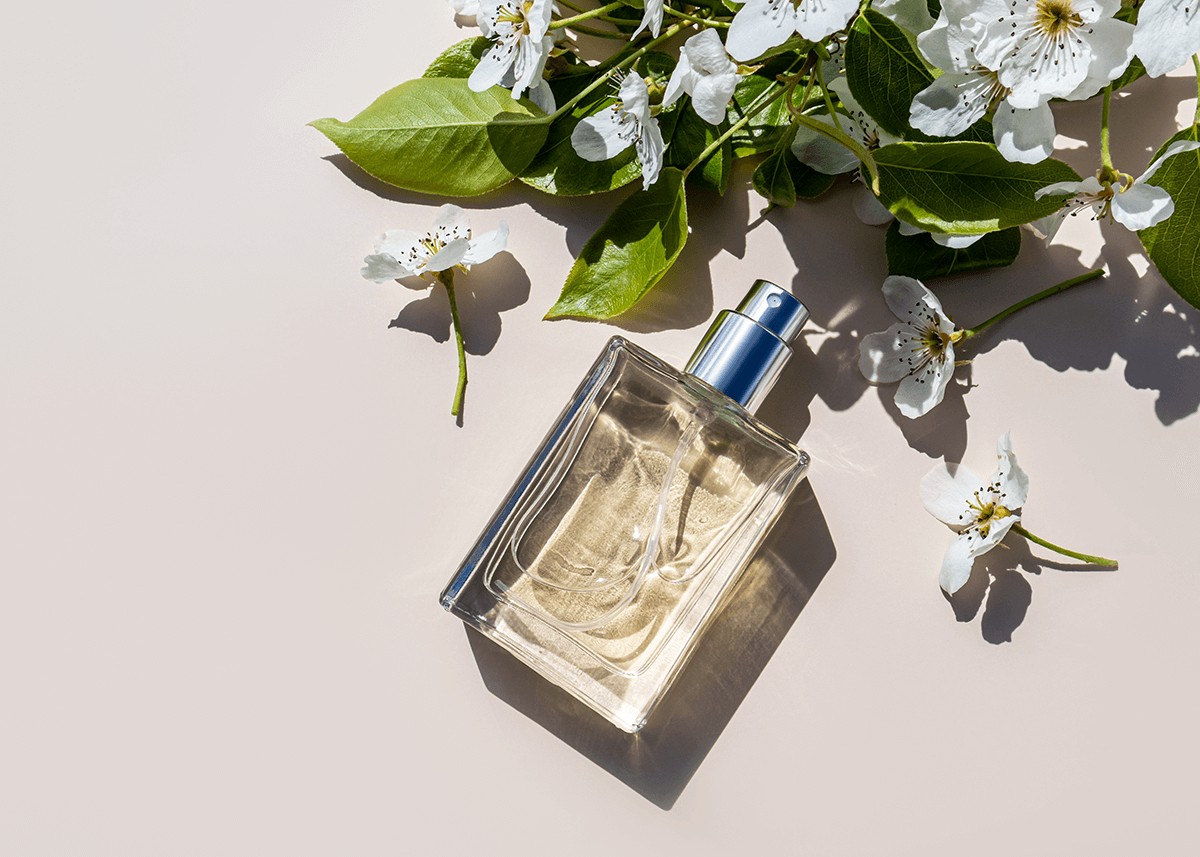 perfume laying on table with flowers around