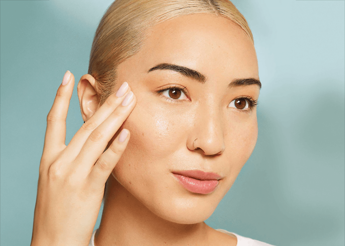 rare beauty tinted moisturizer applying to face with fingers