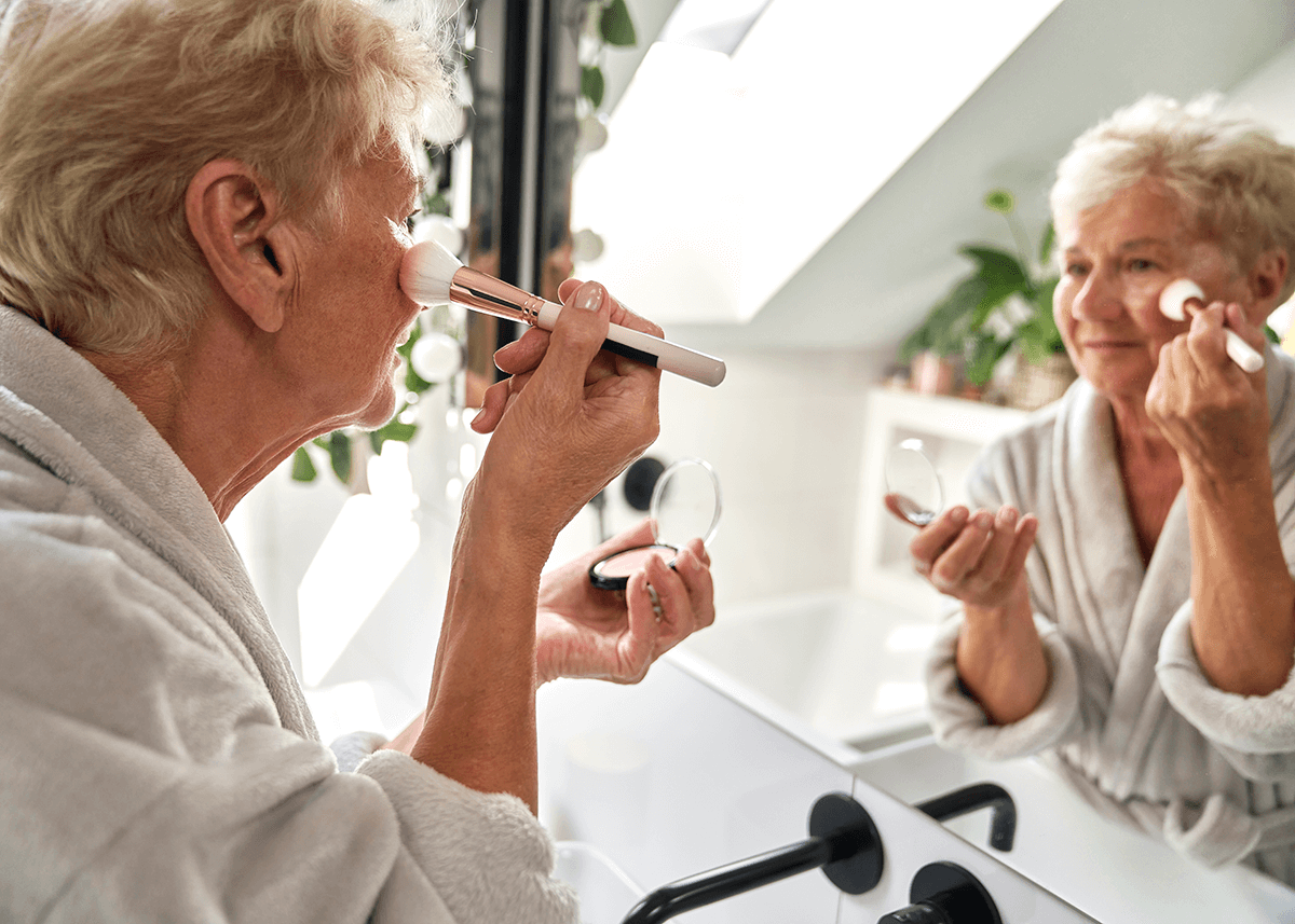 senior woman doing makeup in bathroom