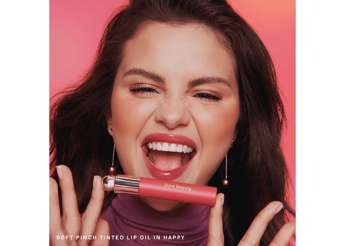 soft pinch tinted lip oil selena gomez posing with product