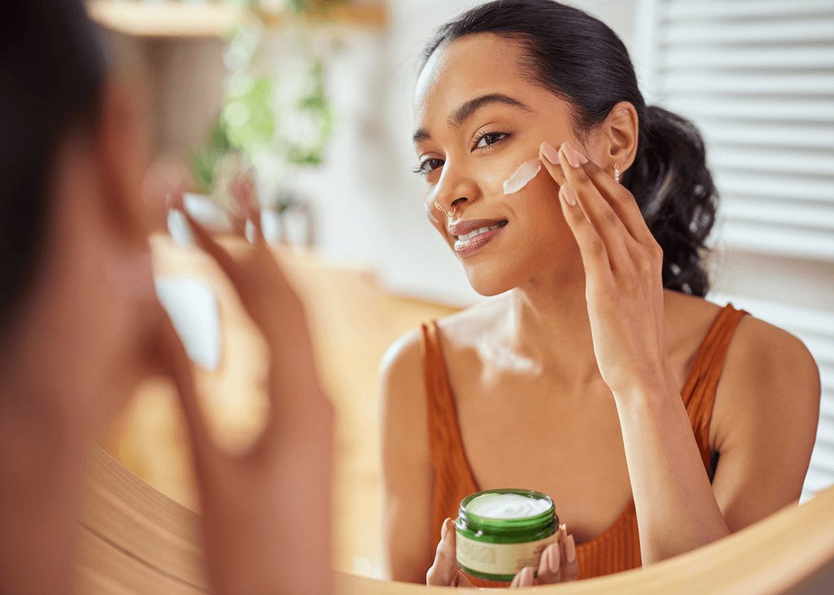 Woman applying face cream during morning routine