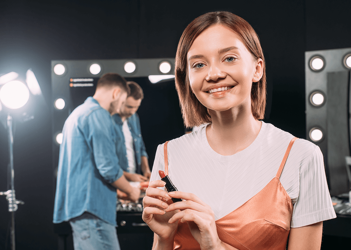 woman back stage applying lipstick