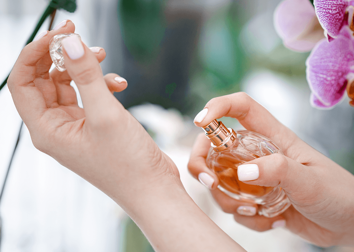 woman spraying perfume onto wrist