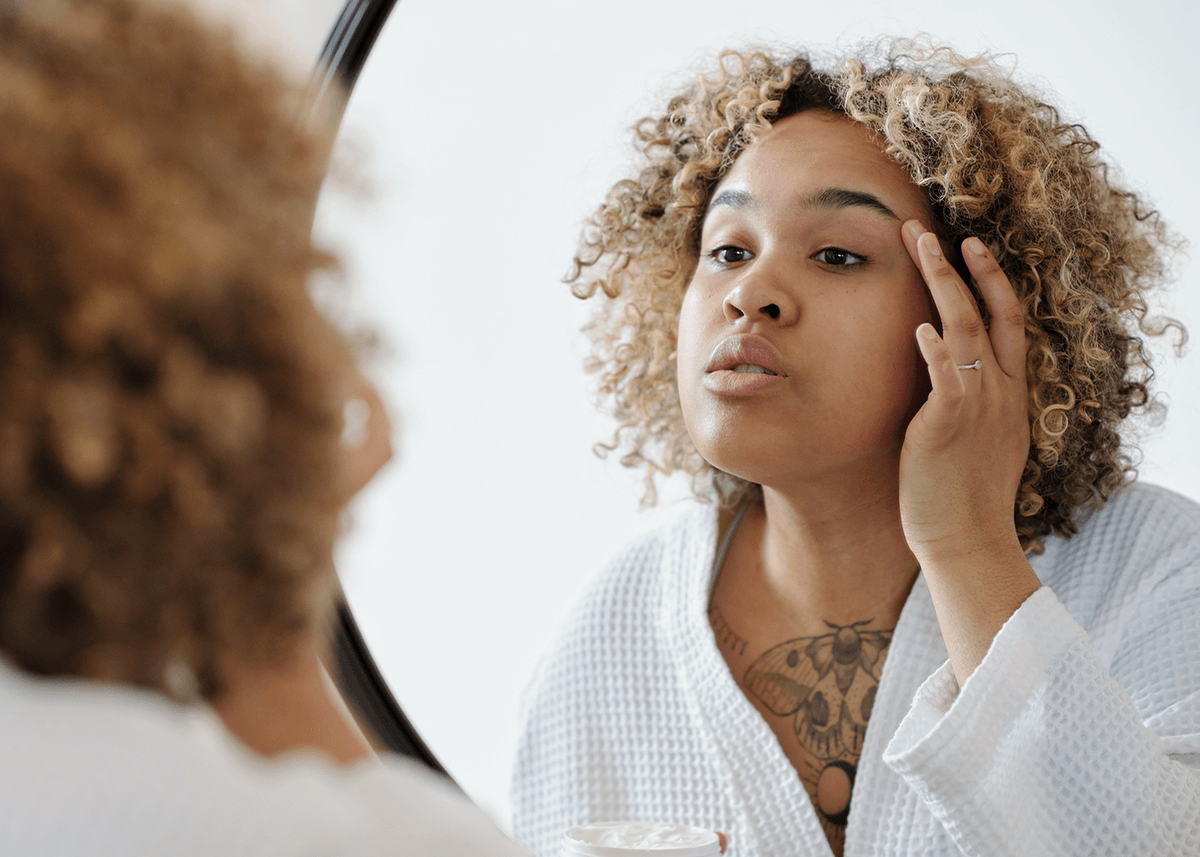 A woman preparing her skin for applying eyeliner